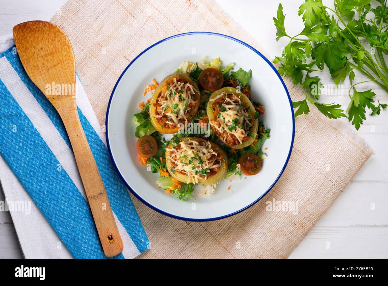 Patate al forno ripiene di carne e cotte al forno. Tavolo con vista dall'alto e decorazioni. Foto Stock