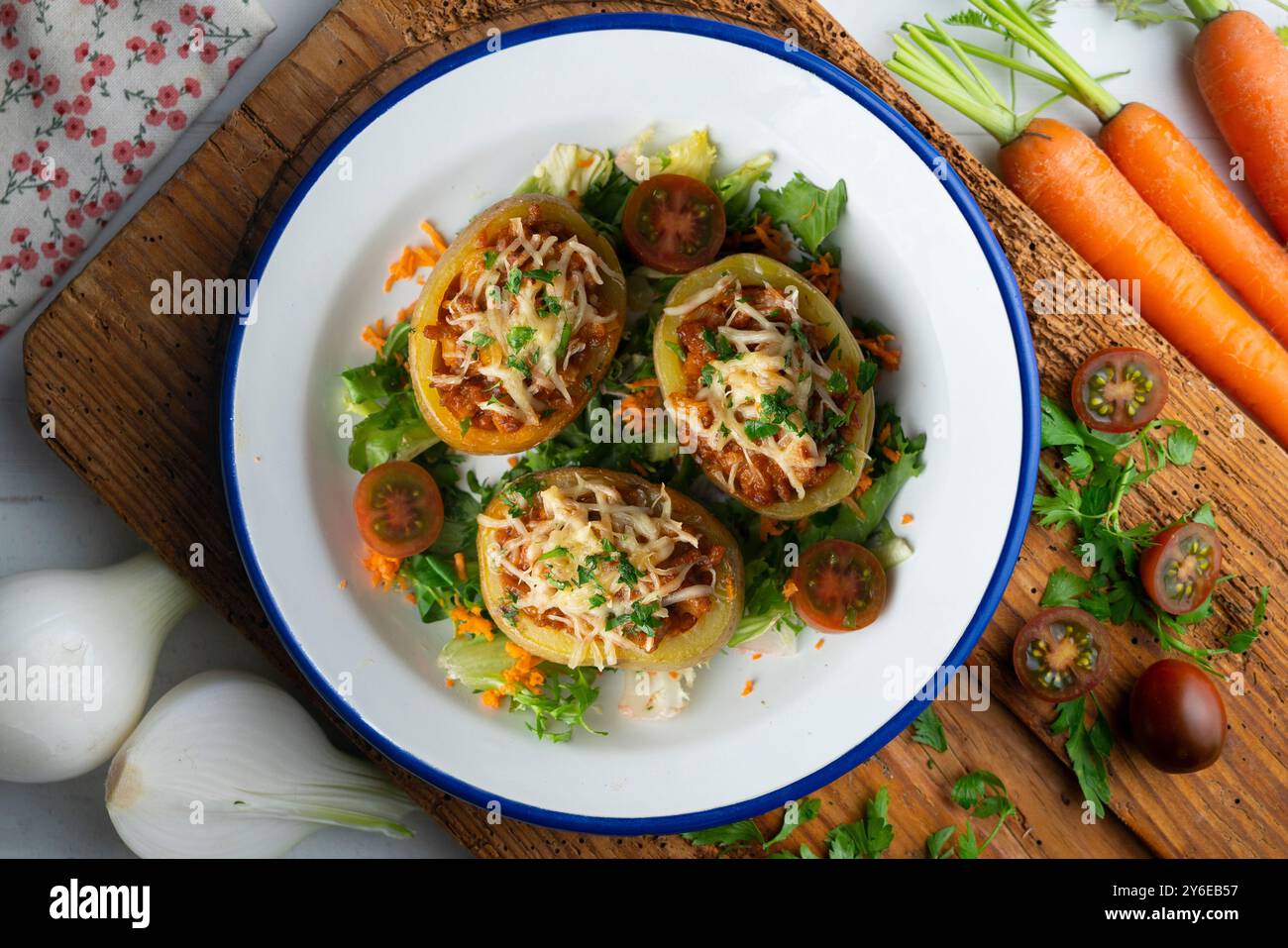 Patate al forno ripiene di carne e cotte al forno. Tavolo con vista dall'alto e decorazioni. Foto Stock