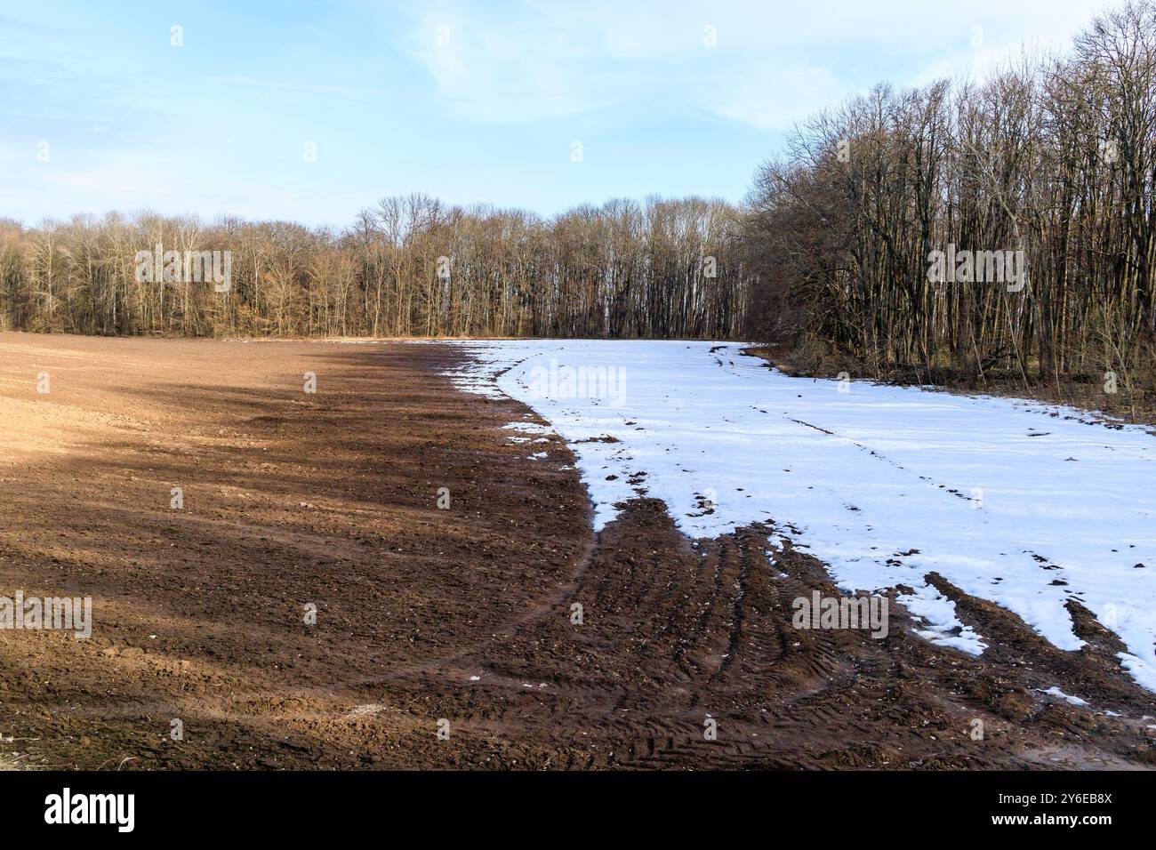 Scioglimento della neve su un campo arato all'inizio della primavera. Terreno nero fertile Foto Stock