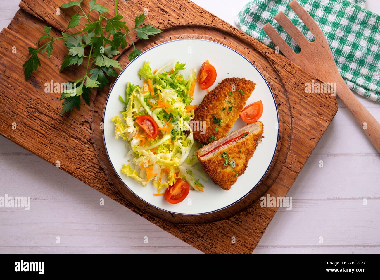 Cachopo asturiano. Filetto di manzo impanato ripieno di formaggio e pepe. Tavolo con vista dall'alto e decorazioni. Foto Stock