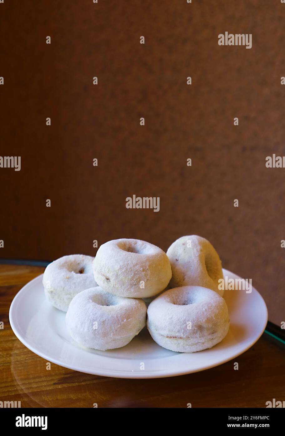 Piatto di deliziose noci di zucchero a velo cotte su un tavolo di legno Foto Stock