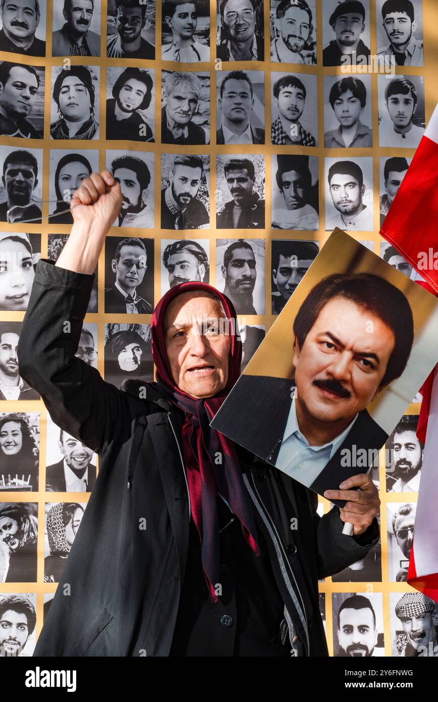 Ritratto di una donna, pugno sollevato, di fronte ai volti martiri della rivolta in Iran 2022 - 2023. Dimostrazione per celebrare il secondo anniversario della rivolta in Iran, per denunciare la brutale repressione del regime iraniano e l'escalation delle esecuzioni negli ultimi mesi. Organizzato da varie organizzazioni. Francia, Parigi, 13 settembre 2024. Foto di Patricia Huchot-Boissier / Agence DyF. Foto Stock