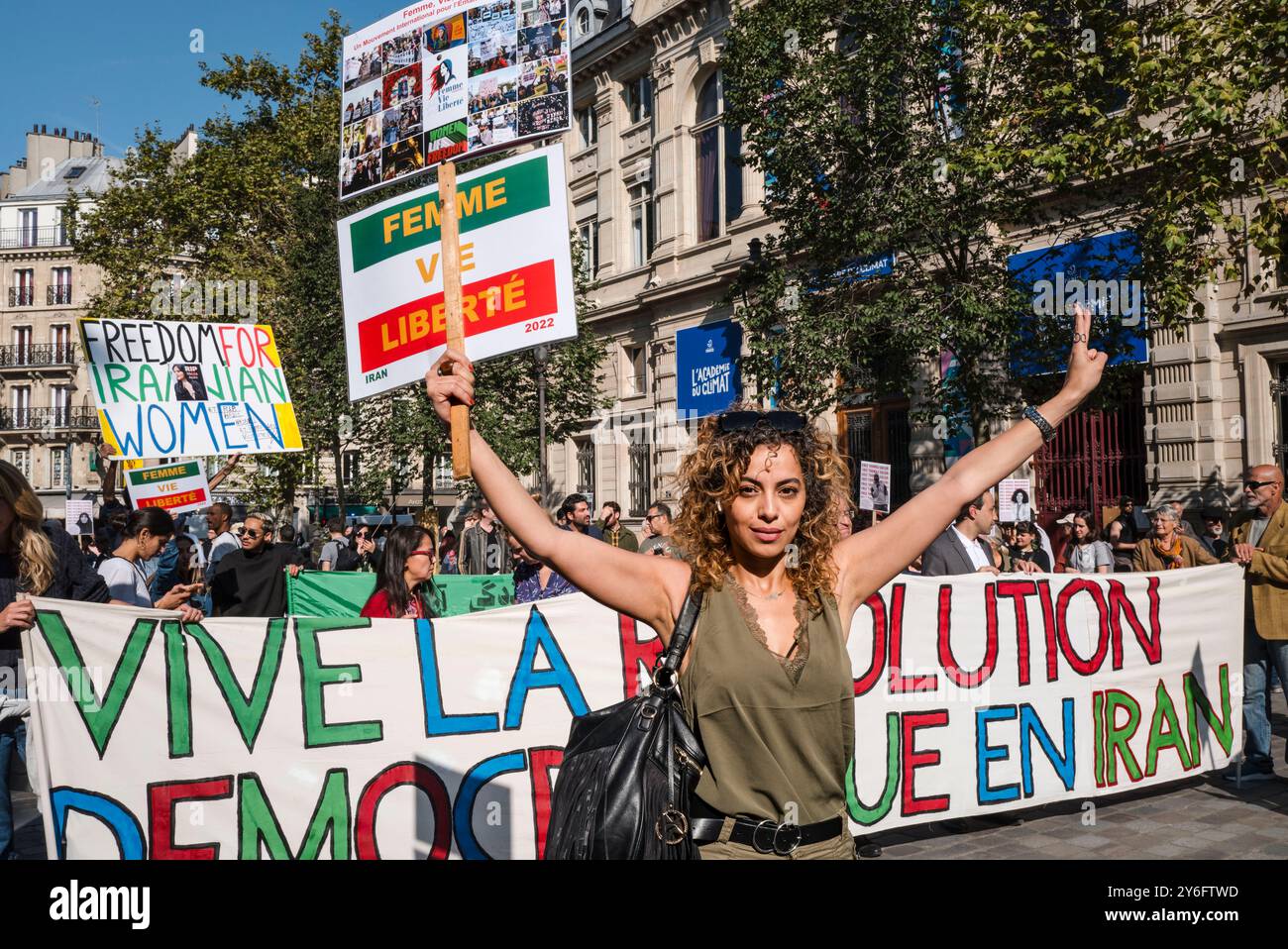 Una donna alla fine della manifestazione con un cartello, Woman Life Free, un movimento internazionale per l'emancipazione femminile. Davanti allo striscione, lunga vita alla rivoluzione democratica in Iran. Donna vita libertà. Manifestazioni in occasione di due anni dall'assassinio di Jina Mahsa Amini, avvenuto il 16 settembre 2022 a Teheran, e per sostenere il popolo iraniano nella sua ricerca della libertà, della laicità e della democrazia. Francia, Parigi, 15 settembre 2024. Foto di Patricia Huchot-Boissier / Agence DyF. Foto Stock