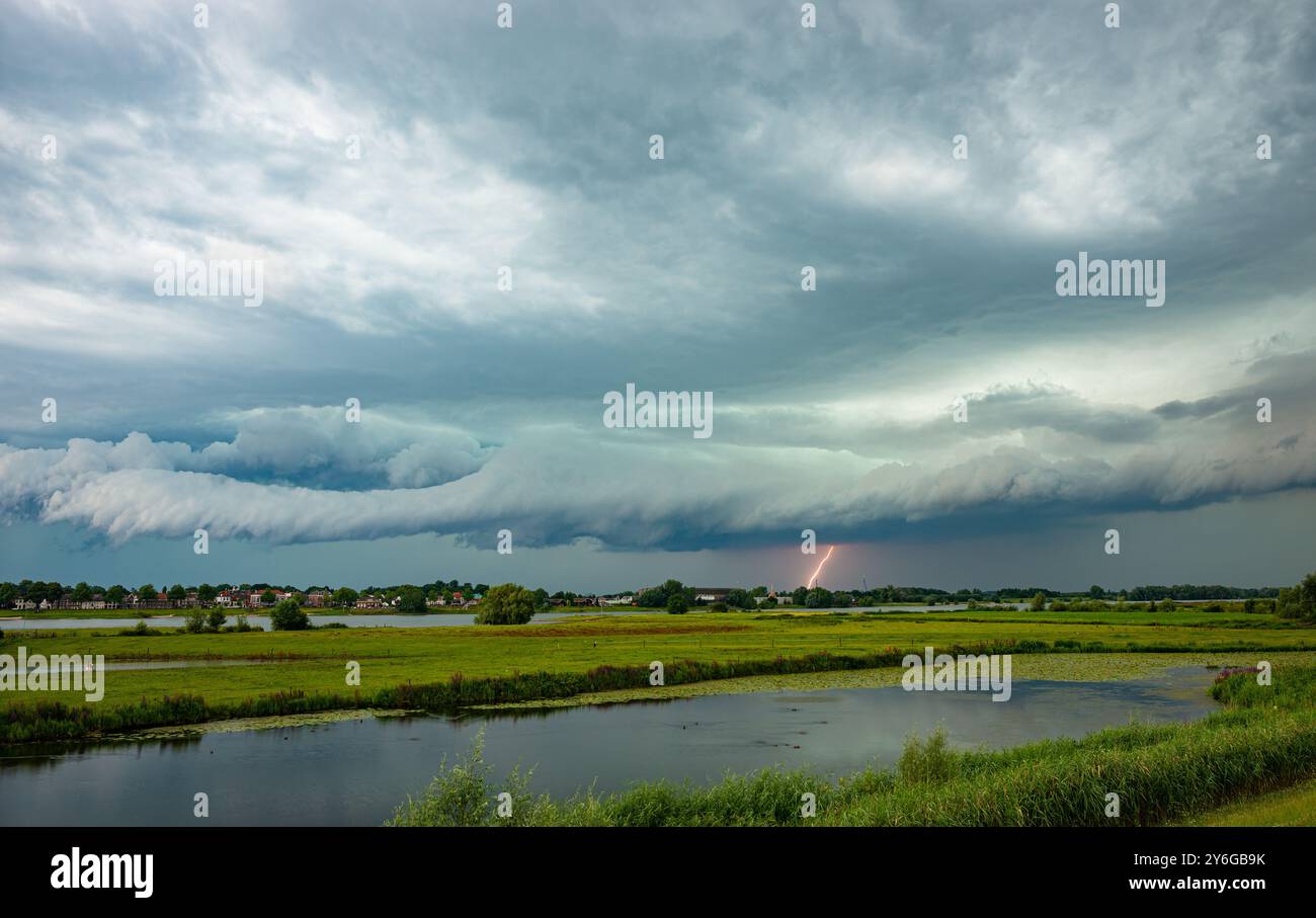 Minaccioso arco o nuvola di scaffali con fulmini sull'ampio paesaggio olandese Foto Stock
