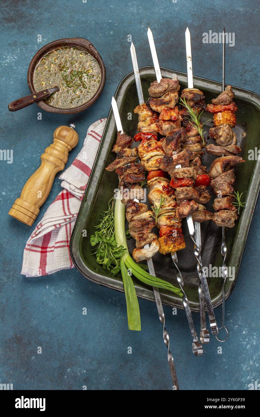 Cibo, cibo, carne di maiale grigliata barbecue, spiedini di pollo e verdure su vassoio Vista dall'alto, disposizione piatta. Sfondo blu Foto Stock