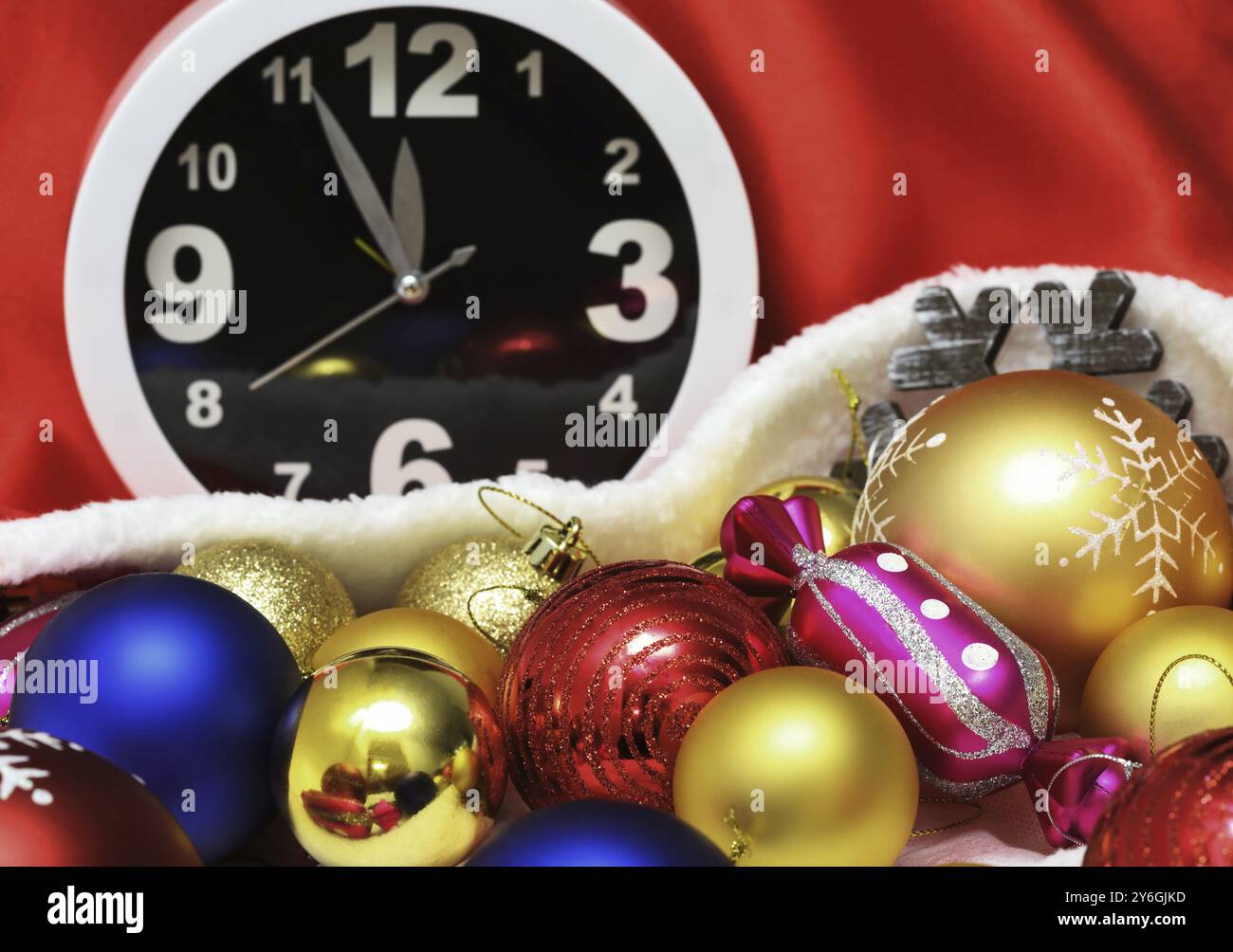 Orologio e palle di Natale e giocattoli in un sacchetto rosso Foto Stock