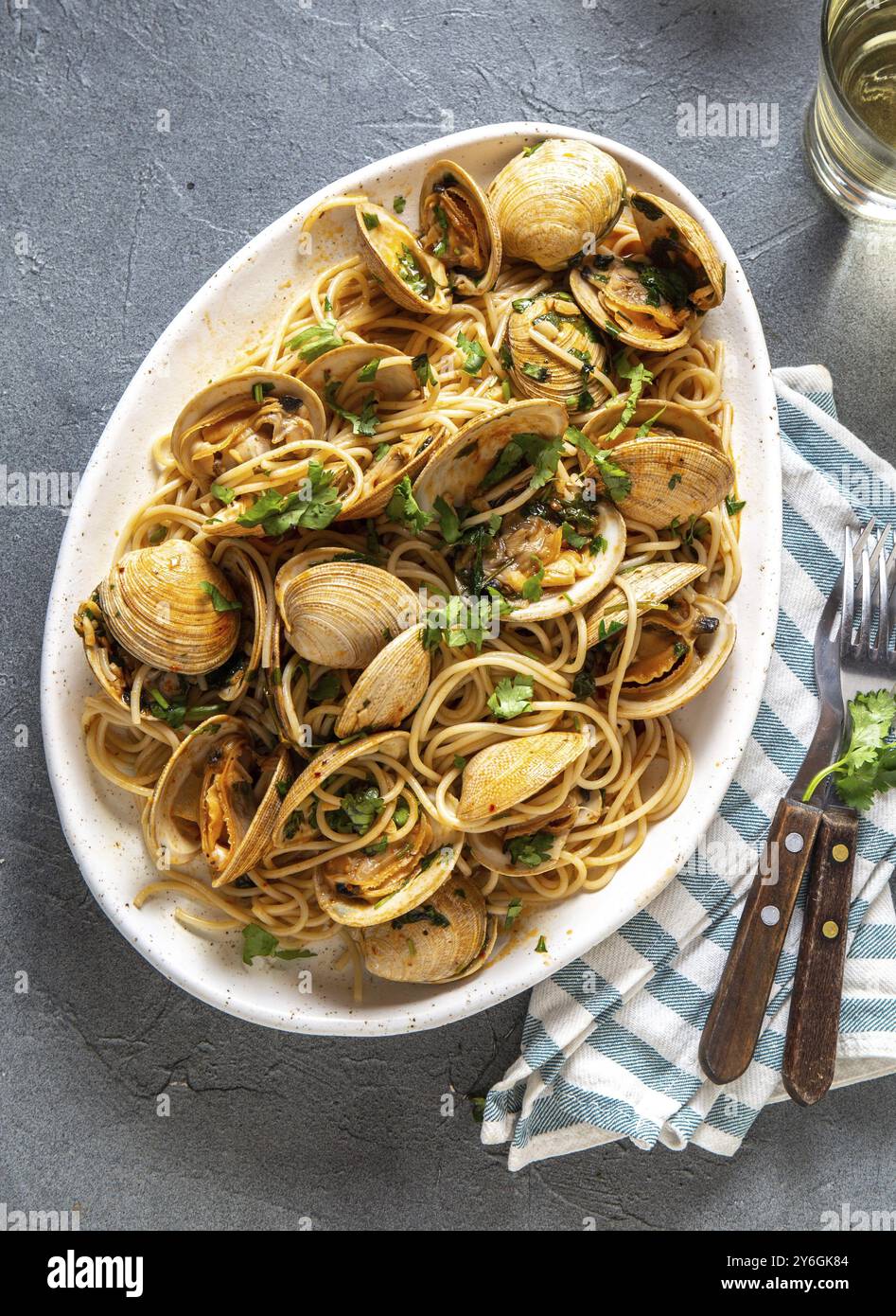 Cibo, cibo, pasta di pesce. SPAGHETTI ALLE VONGOLE ITALIANI. Spaghetti di vongole su piatto bianco con vino bianco, fondo grigio. Vista dall'alto Foto Stock