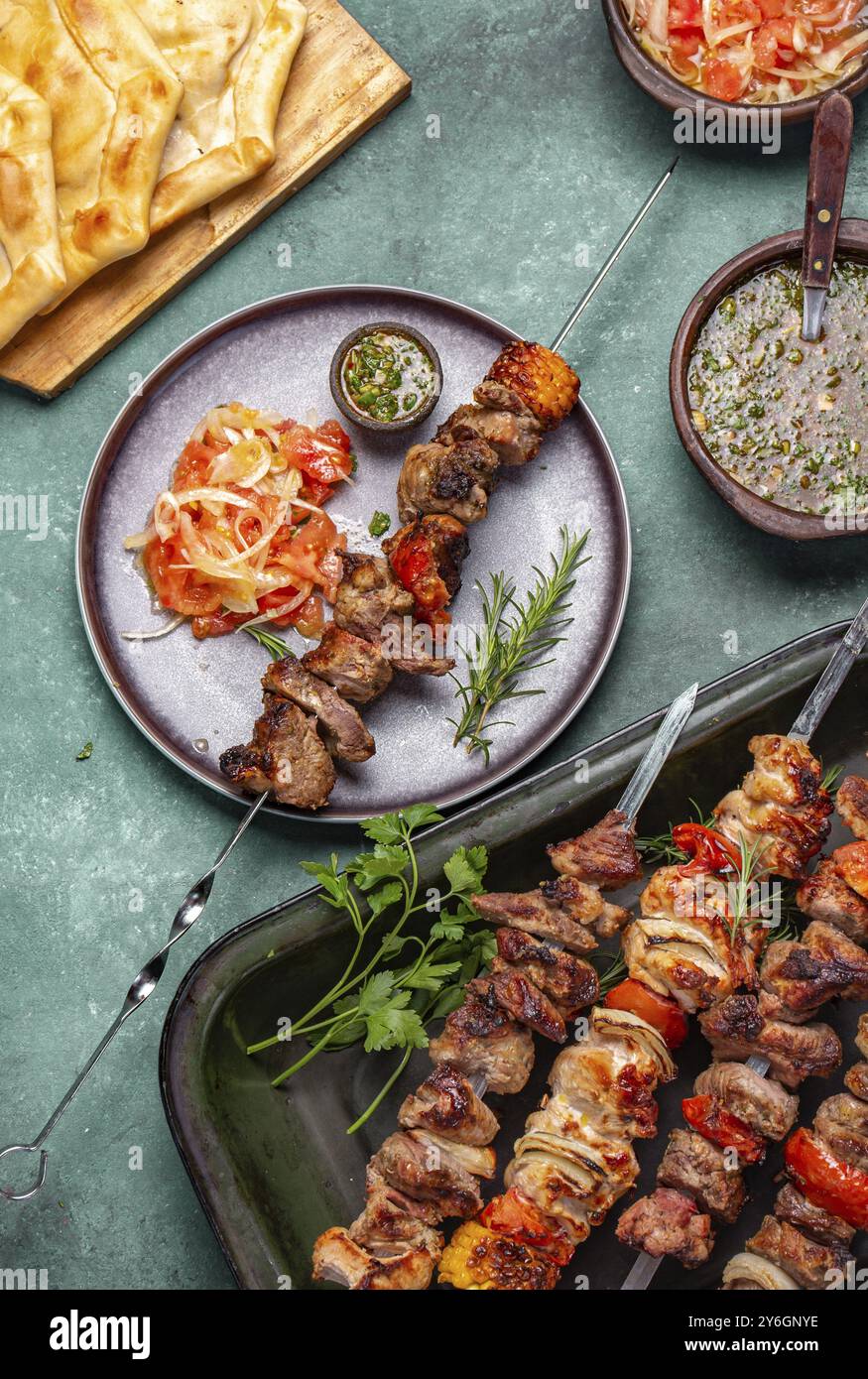 Cibo, cibo, spiedini grigliati di carne di maiale e verdure su piatto grigio, vista dall'alto, piatto piatto Foto Stock