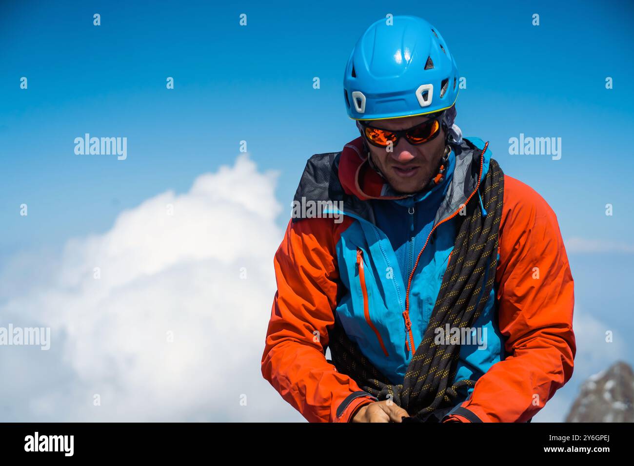 L'uomo con occhiali da sole sta salendo in montagna. Foto Stock