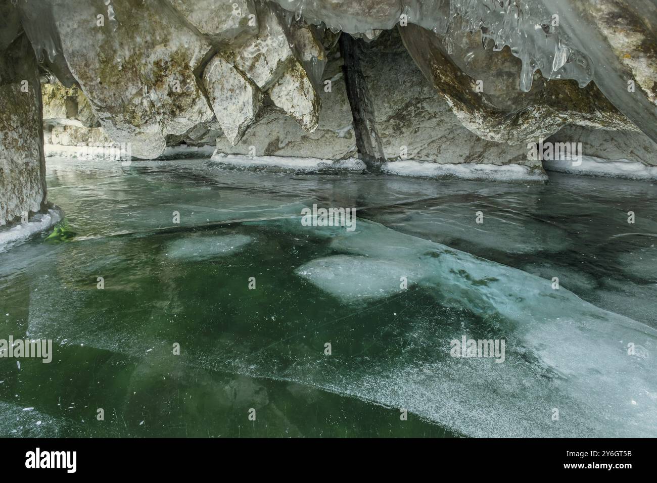 Grotta di ghiaccio sul lago Baikal in inverno. Ghiaccio trasparente trasparente e ghiaccioli nella grotta. Isola di Olkhon, Baikal, Siberia, Russia, Europa Foto Stock