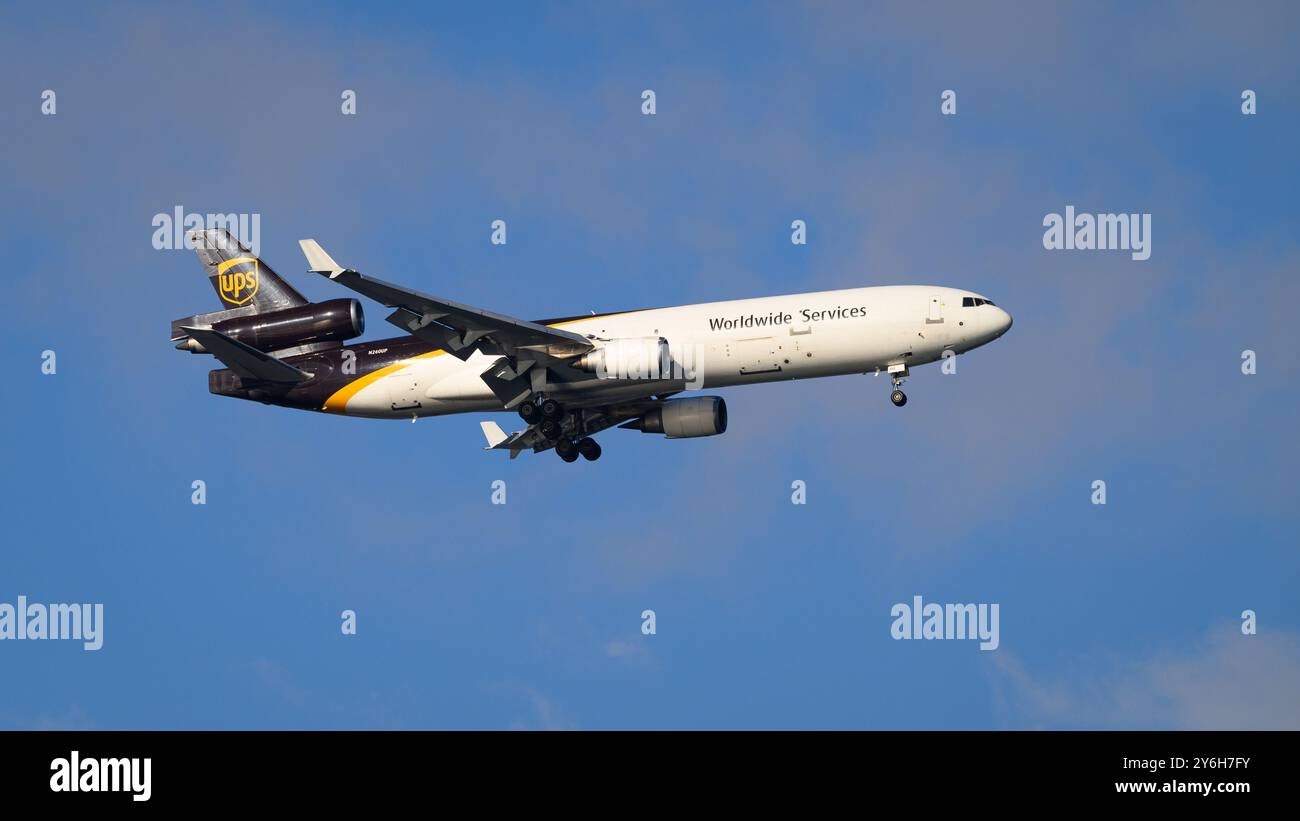 Seattle - 18 agosto 2024; livrea UPS United Parcel Service Boeing McDonnell Douglas MD 11 tri jet in volo contro il cielo blu con le ruote abbassate Foto Stock