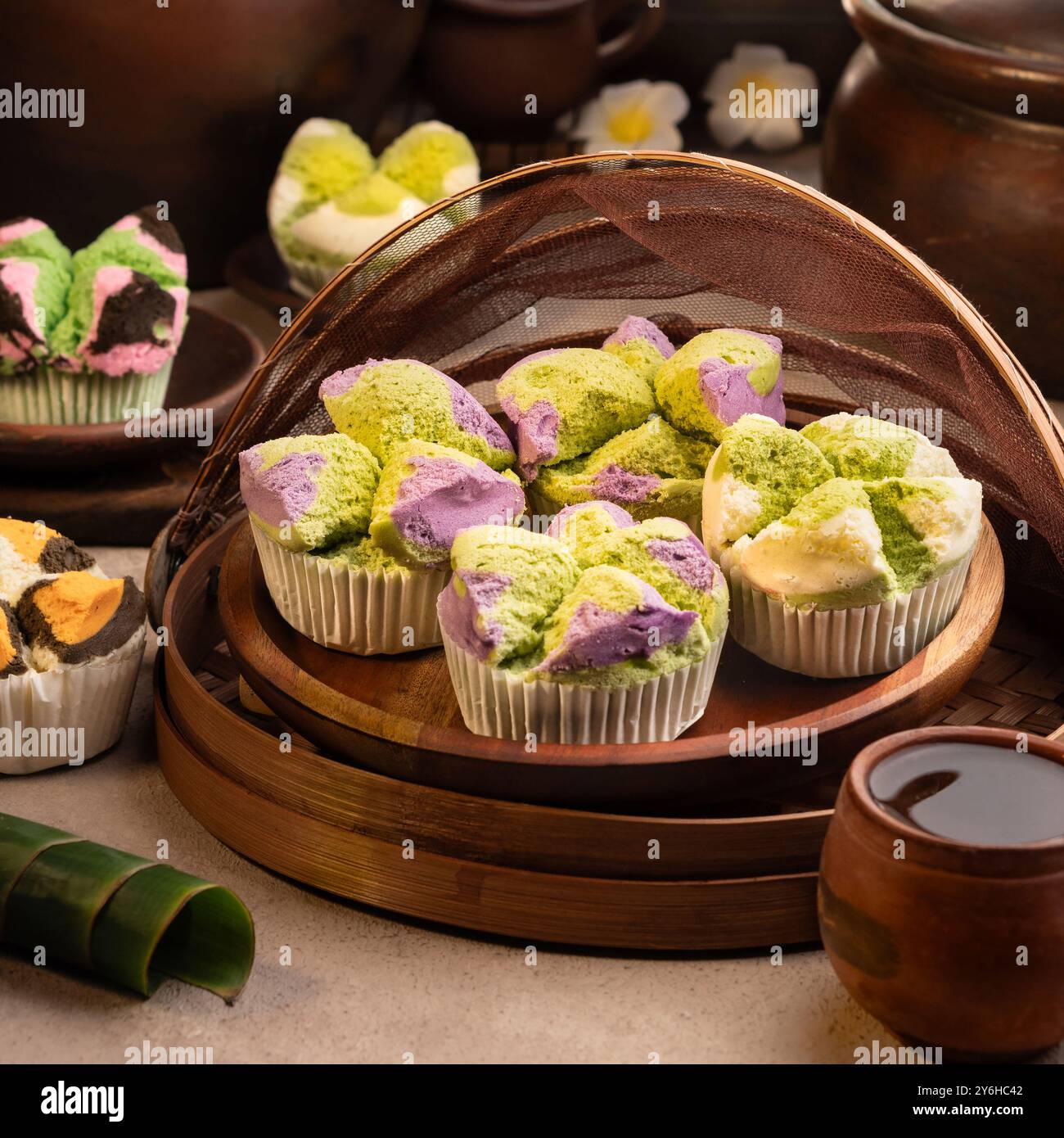 Torta di spugne al vapore, Bolu Kukus Mekar presenta una consistenza soffice e colori vivaci. È leggera, umida e spesso ricoperta di cocco o pandan. Foto Stock