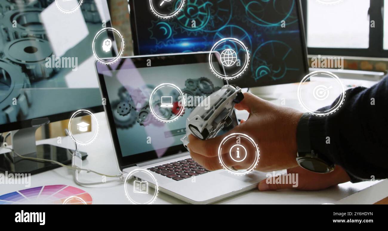 Immagine delle icone di un uomo d'affari caucasico che tiene in mano il modello di auto e utilizza un computer portatile in ufficio Foto Stock