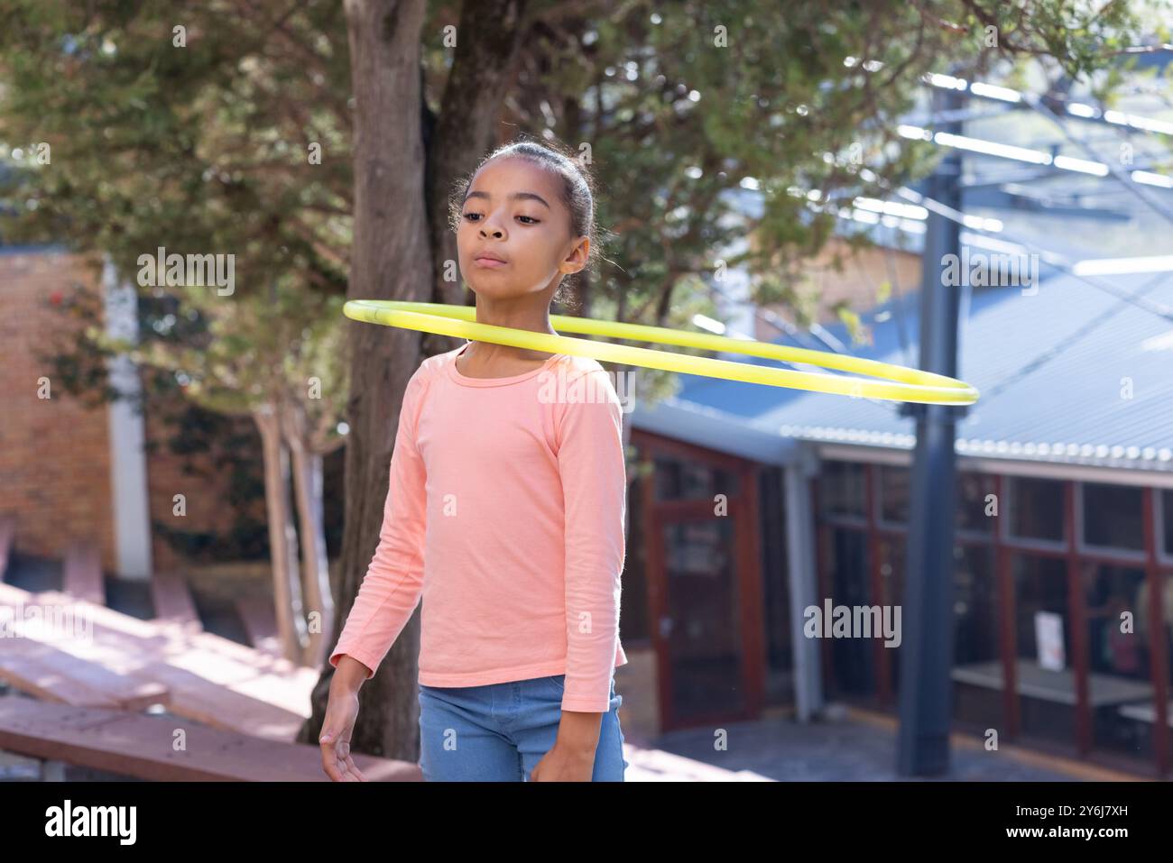 Hula hooping, ragazza afroamericana in classe che si diverte a praticare attività all'aperto durante la pausa Foto Stock