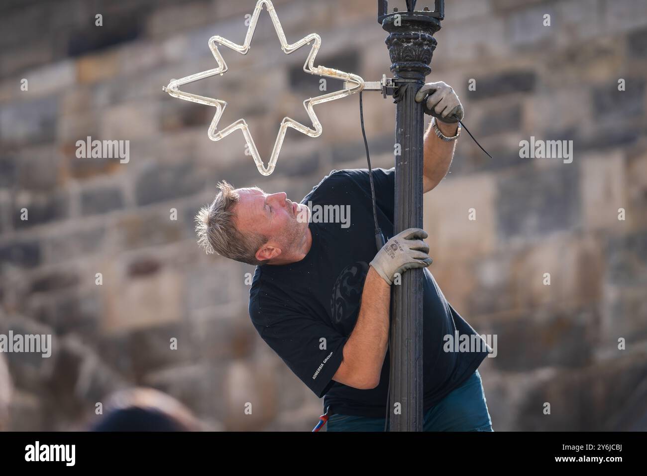 Praga Repubblica Ceca, 09192024. Un lavoratore installa una decorazione natalizia vicino al Ponte Carlo. Foto Stock