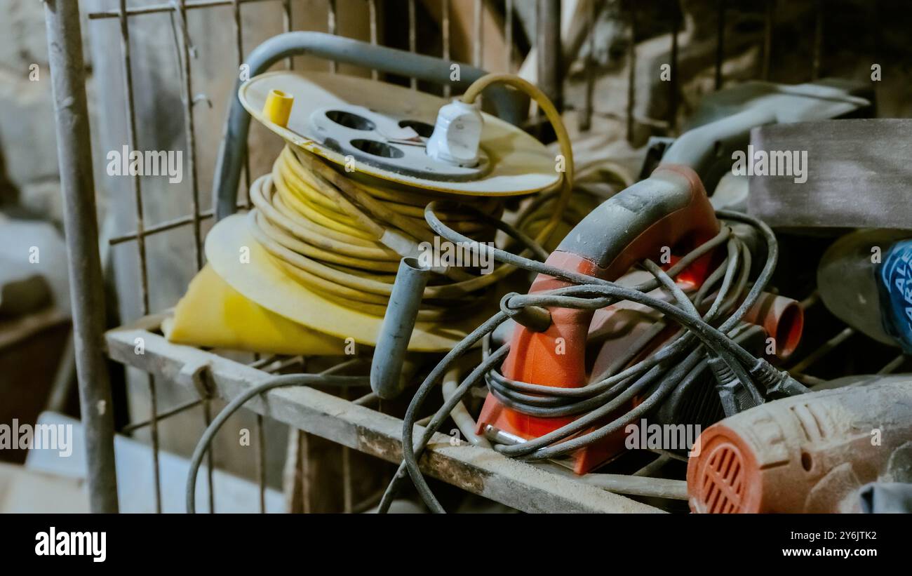 Vari utensili: Lima, cacciavite, martello, pinze, utensili da giardino sono esposti su scaffale in legno all'interno di officine o fabbriche rustiche, officina in una Foto Stock