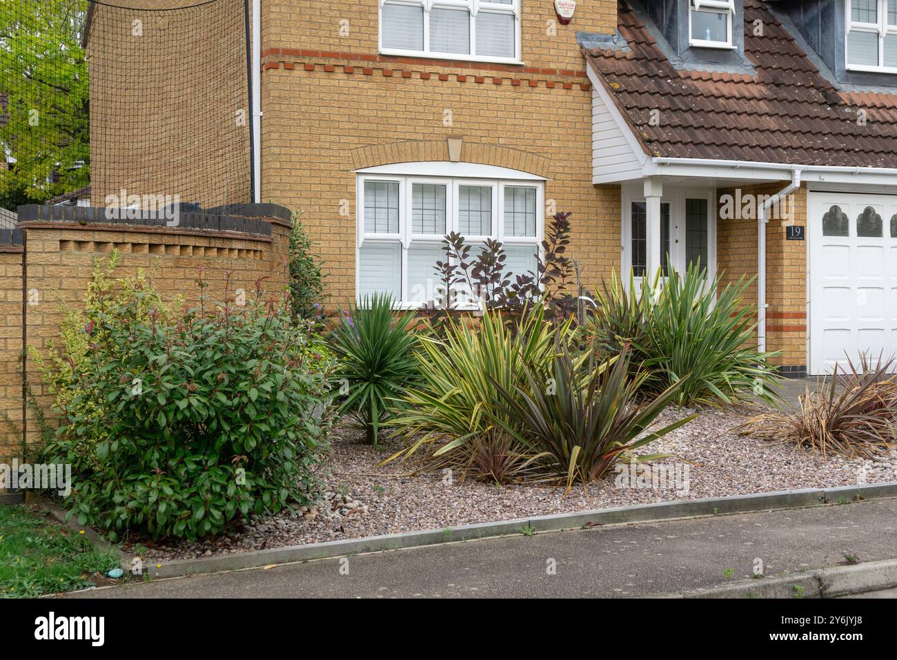 Giardino di ghiaia a bassa manutenzione con piante e arbusti, casa indipendente degli anni '1990, Wootton, Northampton, Northamptonshire, REGNO UNITO Foto Stock