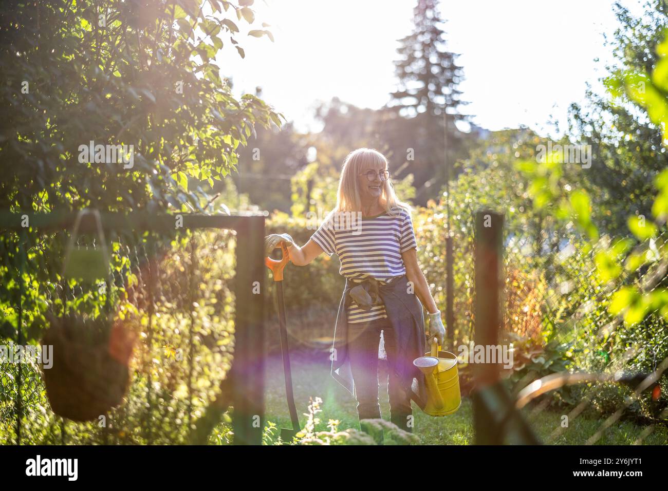 Donna anziana che lavora alla sua assegnazione in una giornata di sole Foto Stock