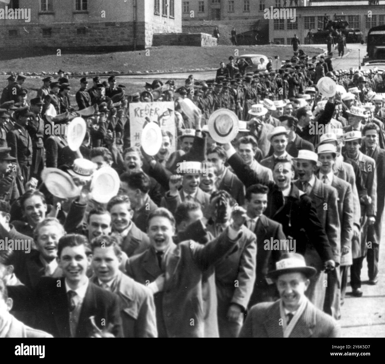 Hemer , Westfalia meridionale soldati tedeschi de-mobbati 110 giovani soldati tedeschi occidentali dimessi marciano attraverso le porte della caserma Bluecher sventolando i loro cappelli di paglia . 2 aprile 1958 Foto Stock