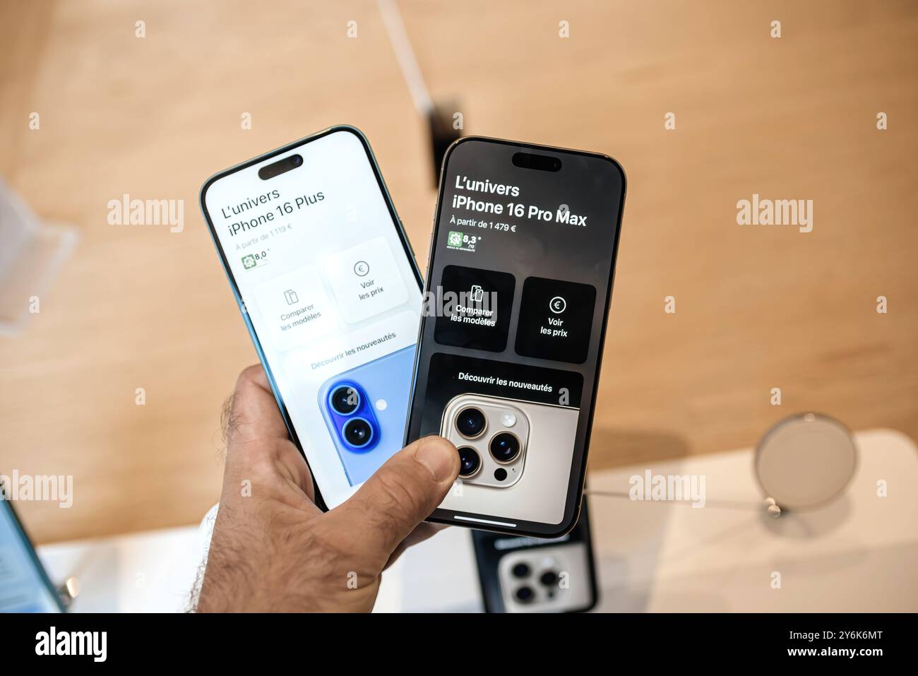 Parigi, Francia - 20 settembre 2024: Un uomo tiene a mano sia l'iPhone 16 Pro Max che 16 Pro Plus, confrontando quale telefono è migliore il giorno del lancio Foto Stock
