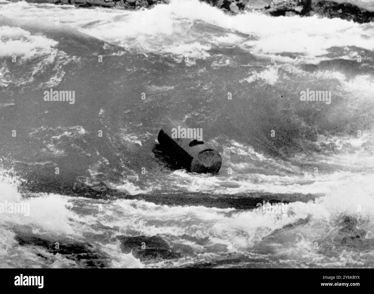 Cascate del Niagara, N.Y.: Un barile gira impotente nelle rapide più basse del fiume Niagara. All'interno c'e' il paracadutista maggiore Lloyd Hill di 35 anni. Per tre ore Hill è stato colpito nell'idromassaggio sotto le rapide fino a quando non è stato portato in acqua più calma e portato in salvo il membro più audace di una famiglia nota per le sue imprese terribili nelle acque del fiume Niagara, dice di essere determinato a rischiare la vita sparando alle cascate stesse in un barile. 2 agosto 1954 Foto Stock