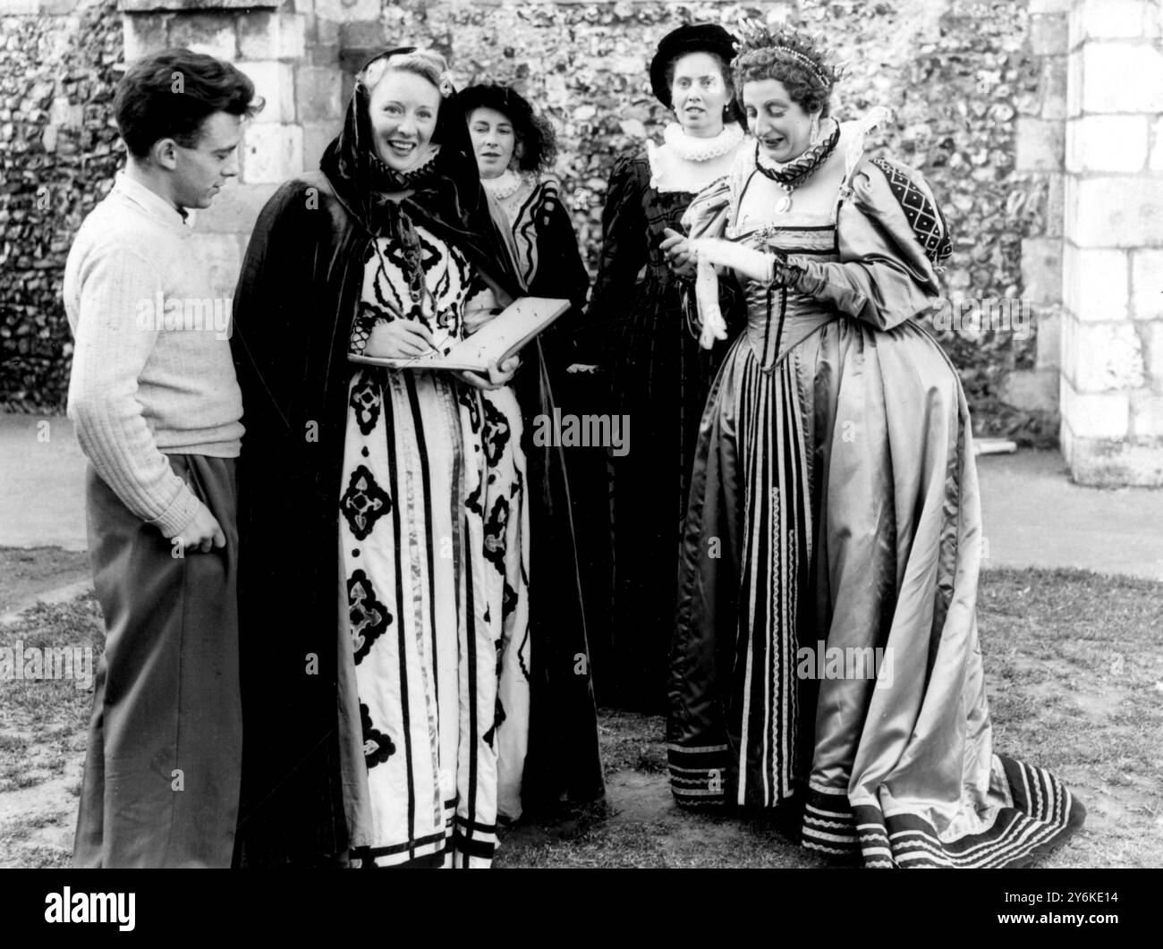 Priory Park, Chichester, Sussex: Per cinque giorni l'opera leggera MERRIE ENGLAND sarà rappresentata all'aperto. La cantante Anne Ziegler firma autografi per i membri della Chichester and Bognor Regis Amateur Operatic Society che si esibiscono in questo spettacolo. Da sinistra ci sono - Peter Wellington, un aiutante nel back-stage, Anne Ziegler, due Dame-in-Waiting e (destra) Audrey Bryant che interpreta la Regina Elisabetta - foto scattata il 24 giugno 1952. ©TopFoto Foto Stock