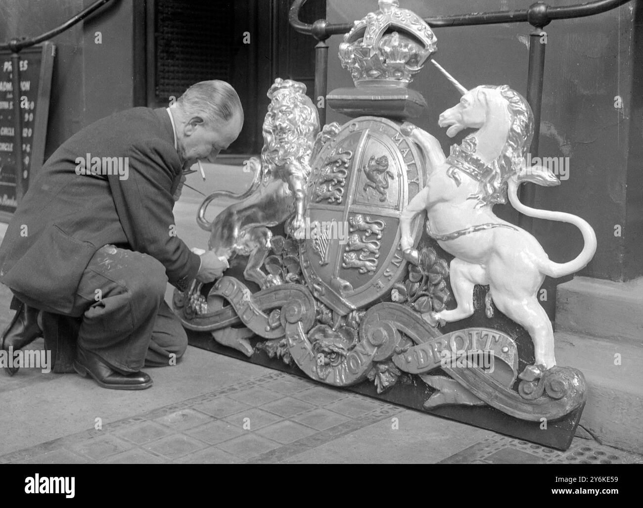 Il Royal Coat of Arms del Theatre Royal , Haymarket , ha tocchi finali applicati da un artista , in preparazione per l' incoronazione . Dopo essere stato ridipinto lo stemma sarà sostituito sopra la porta del famoso teatro . 13 aprile 1953 Foto Stock