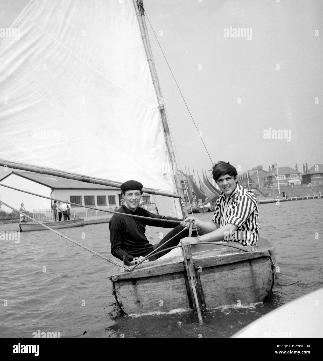 St Annes, Lancashire, Inghilterra: Mike Smith (a sinistra) e Dave Clark (a destra) del gruppo pop Dave Clark Five, rilassati con una sessione in barca a vela sul lago Fairhaven durante una pausa nel loro spettacolo estivo al Winter Gardens Pavilion di Blackpool. 21 settembre 1964 Foto Stock