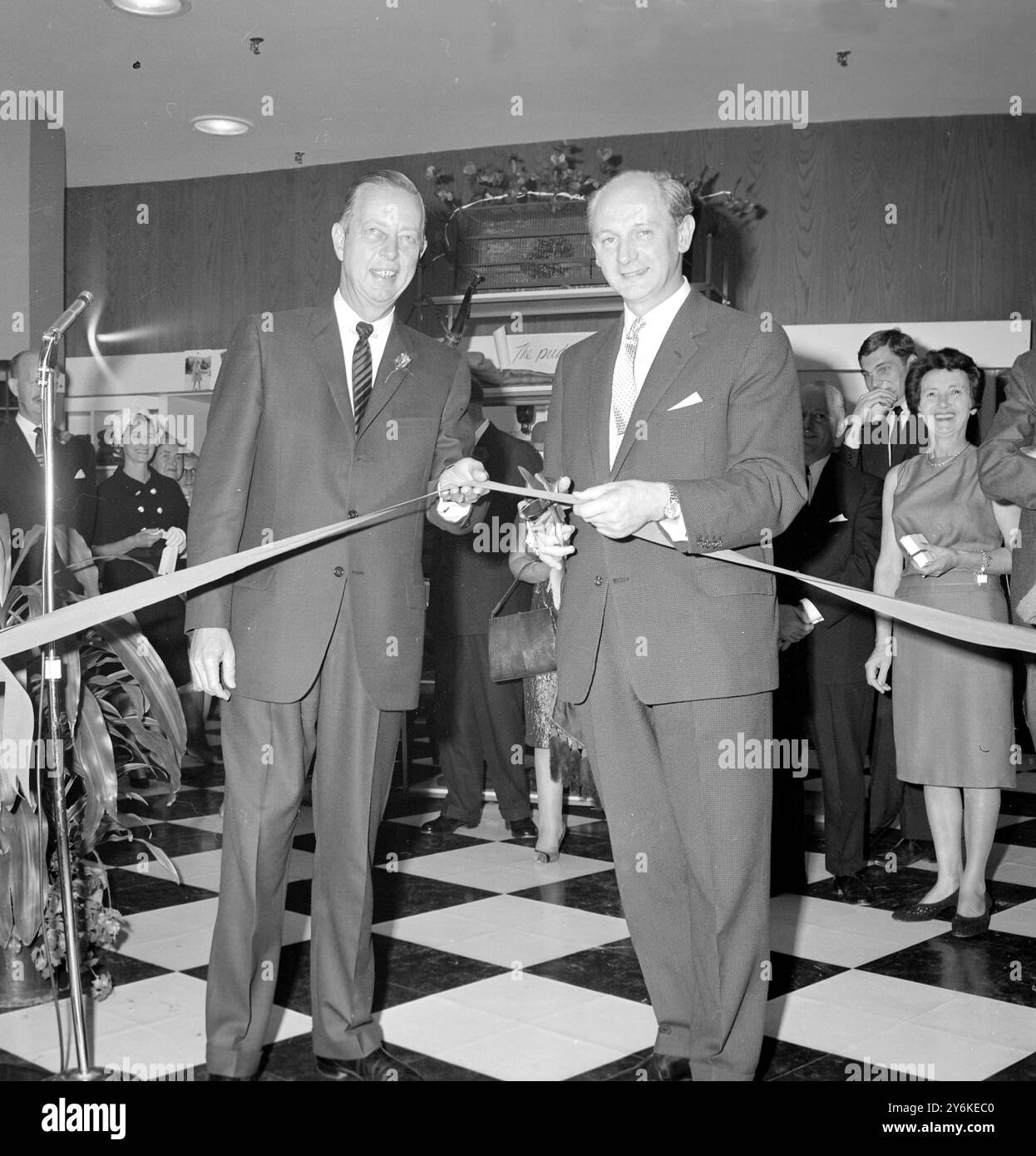 New York, Stati Uniti: Presidente del negozio newyorkese di Lord e Taylor, Melvin E. Dawley (a sinistra) e ministro irlandese per l'industria e il commercio, Jack Lynch (a destra) eseguono una cerimonia di taglio del nastro presso il negozio, il 2 ottobre, per aprire una mostra di prodotti irlandesi in tutto il negozio. La mostra, chiamata "The Pride of Ireland", ha richiesto undici mesi e 48 traversate transatlantiche e più di un milione di dollari dal giorno in cui l'idea è nata all'apertura dello spettacolo. 4 ottobre 1963 Foto Stock
