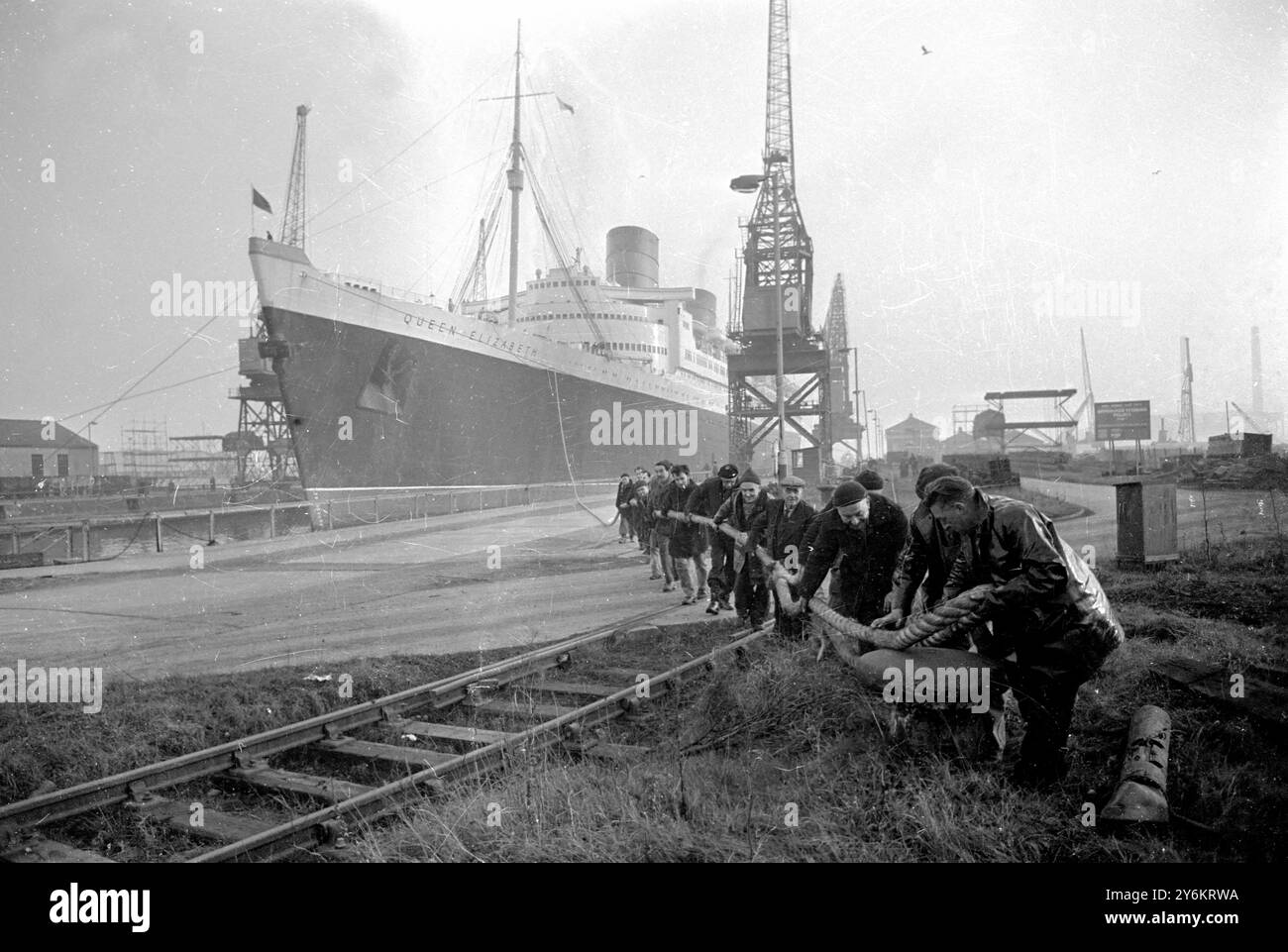 Southampton: Assistita da rimorchiatori e manipolata, la regina Elisabetta II non si fa strada nel bacino di carenaggio - probabilmente per l'ultima volta oggi. Dovrebbe fare la sua ultima corsa atlantica il prossimo ottobre prima di seguire la sua nave gemella "Queen Mary" in pensione. 23 novembre 1967 Foto Stock