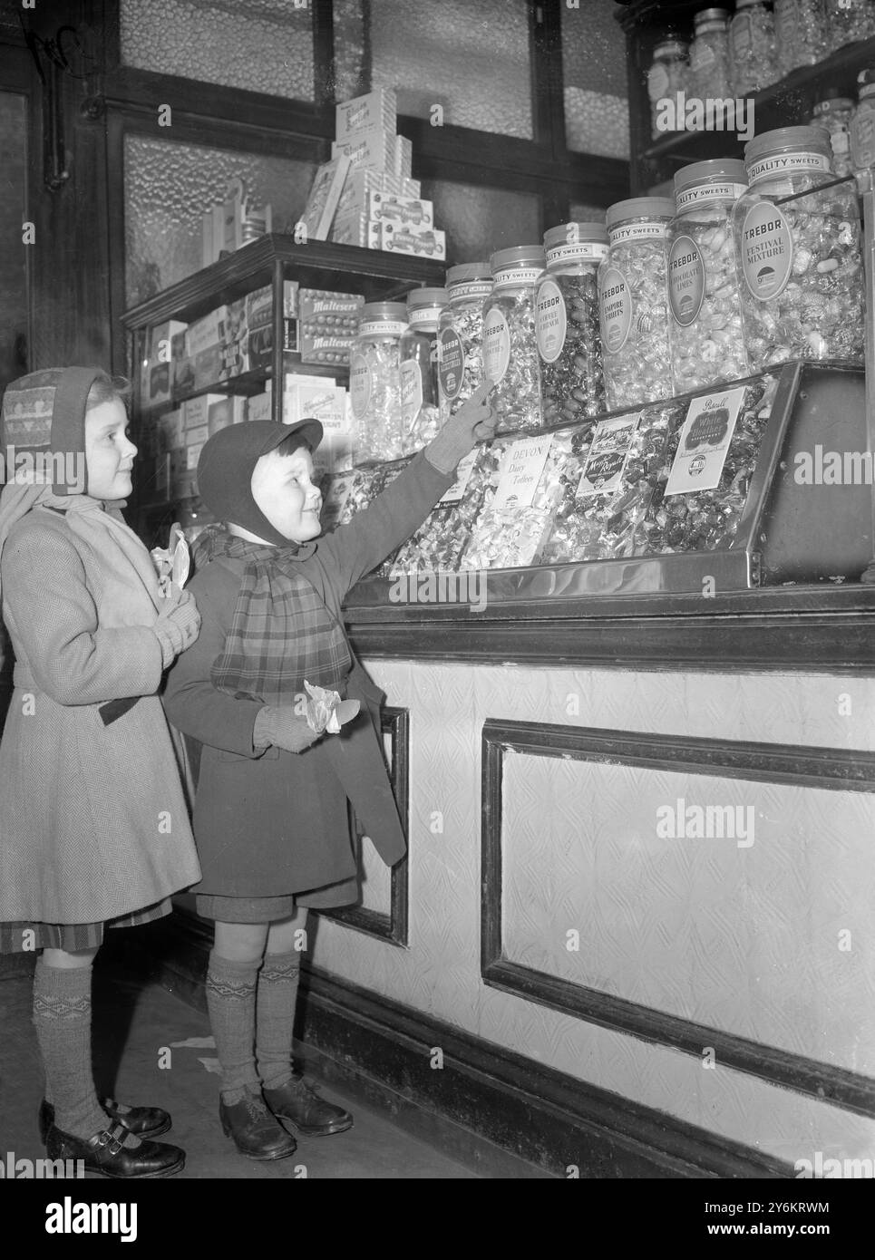 Londra: Giornata di gioia per questi giovani, Linda di 6 anni e Peter Bailey di 4 anni, di Lambeth, mentre visitano un pasticcere e non trovano bisogno di buoni. La fine del razionamento dolce e' stata annunciata ieri sera. È stato introdotto originariamente nel luglio 1942. Il 24 aprile 1949 è stato chiuso, ma è stato reintrodotto il 14 agosto 1949. Dal dicembre 1951, la razione era stata di sei once a persona a settimana. 5 febbraio 1953 Foto Stock