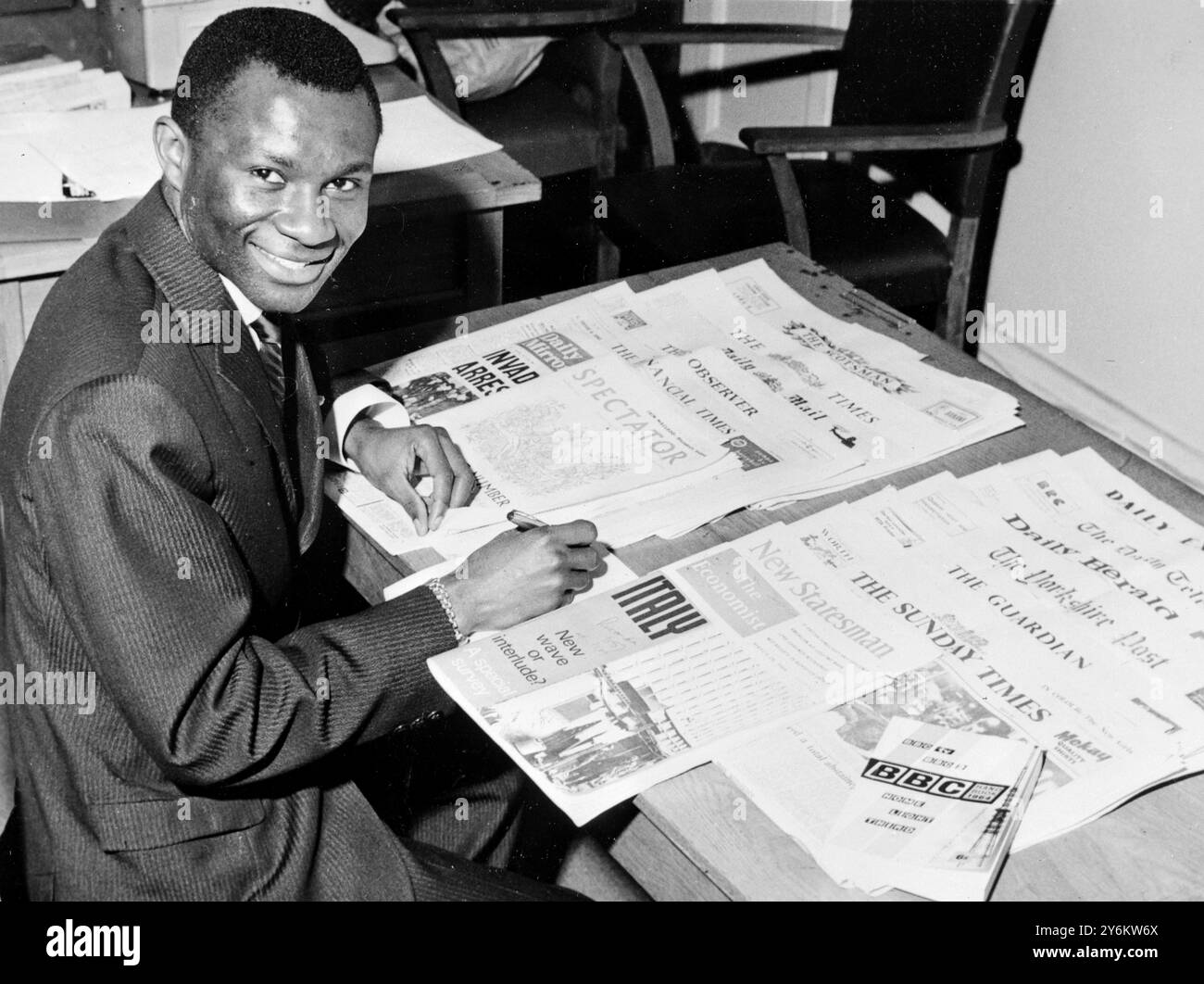 Londra: Hamza Kassongo della BBC Swahili Service Studies alcuni giornali e riviste nazionali britannici per il programma African Affairs in the British Press, il 1 maggio 8 maggio 1964 Foto Stock