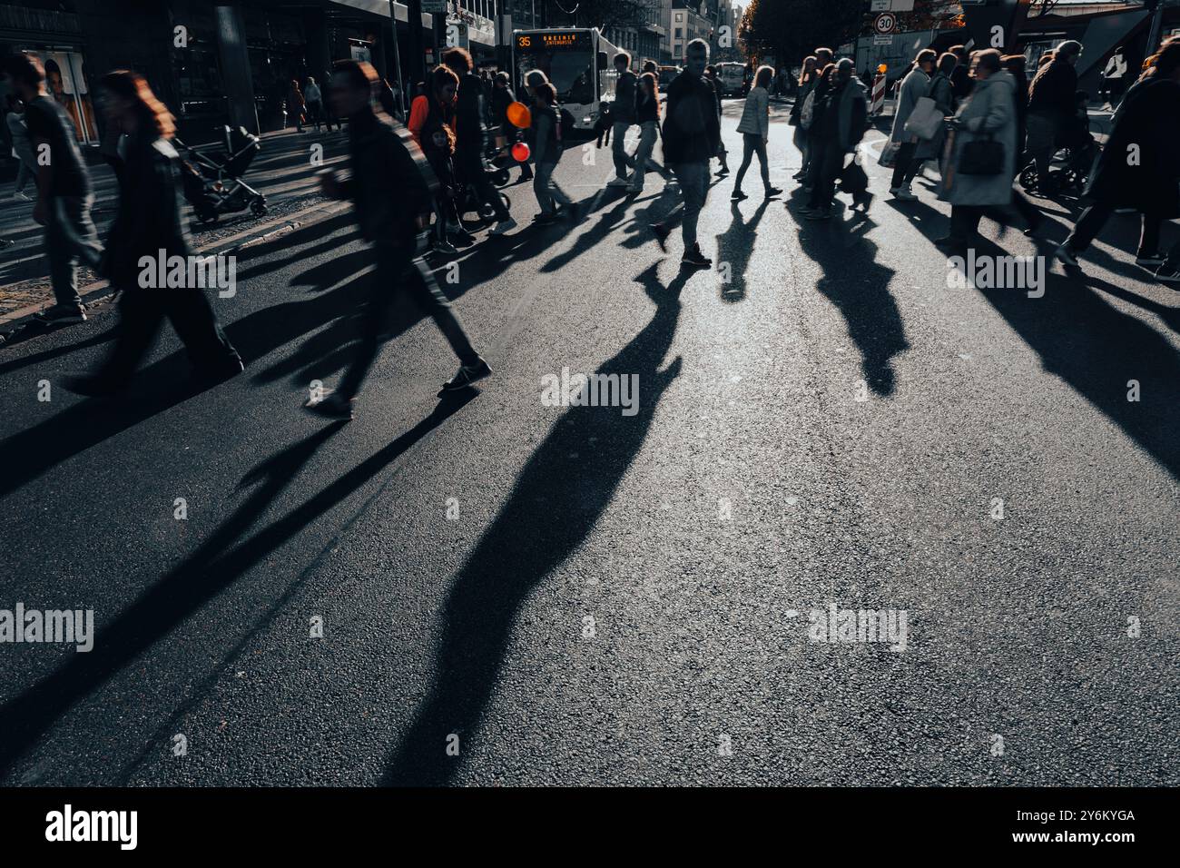 Ombre dei passanti che attraversano un incrocio Foto Stock