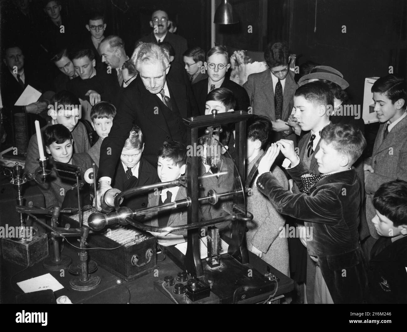 29 dicembre 1949 da questo generatore grezzo, la Ramsden Friction Machine of Glass and Rubber sorse meraviglie elettriche del presente e qui il dottor P Dunsheat lo dimostra ad un pubblico interessato di bambini presso la Royal Institution di Albermarle Street, Londra. Girando la ruota di vetro c'è Charles Thrower. Il dottor Dunsheath ha dato la dimostrazione durante la conferenza annuale ai bambini della Royal Institution. Quest'anno il soggetto era "l'era elettrica e come è iniziata" Foto Stock