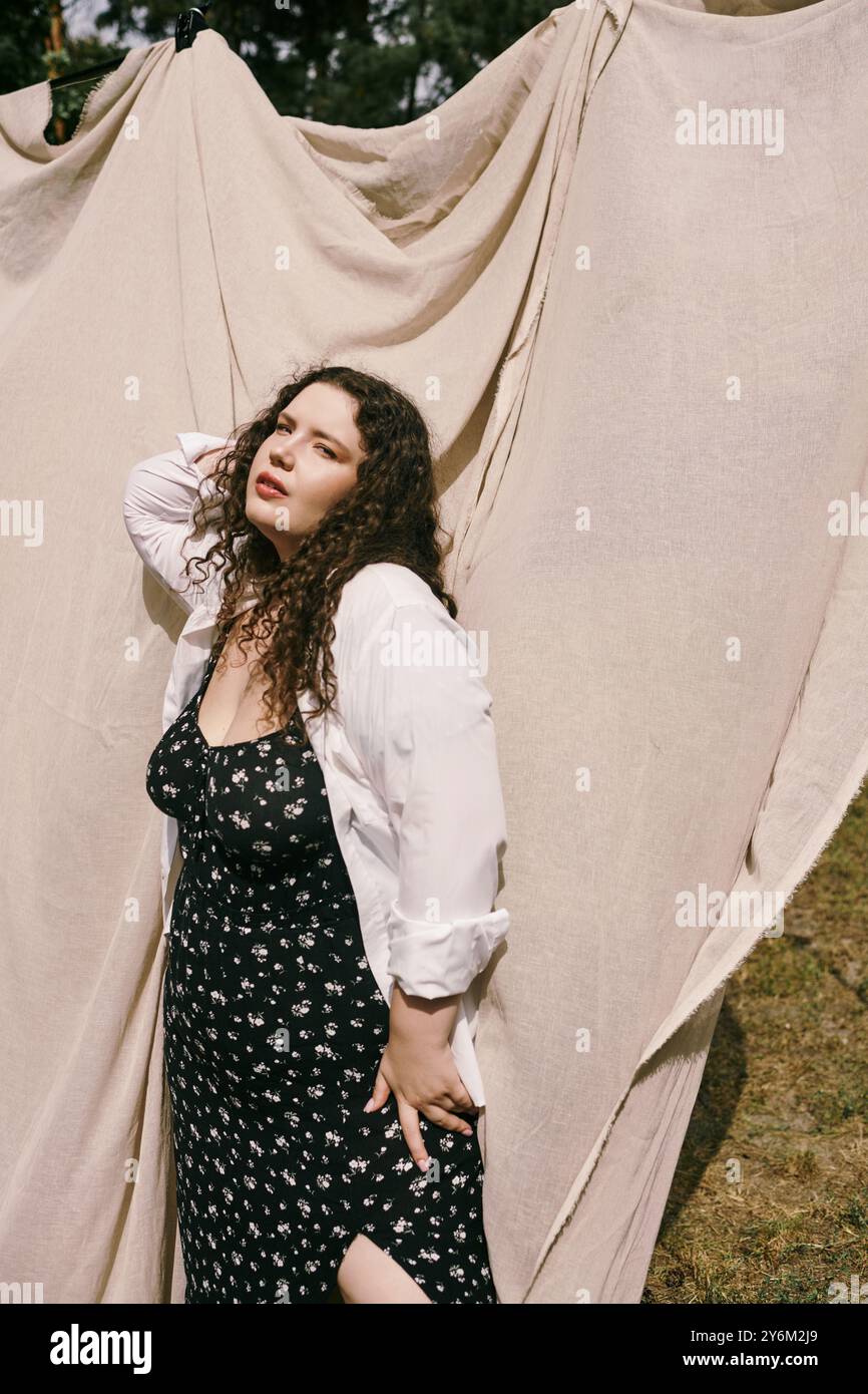 Una donna di grandi dimensioni si trova in un campo vivace, irradiando bellezza naturale. Foto Stock