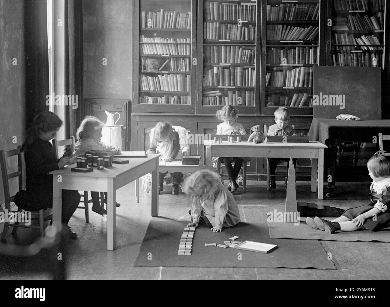 Montessori School a Golders Green, North West London. Bambini che giocano in un salotto/biblioteca. Foto Stock