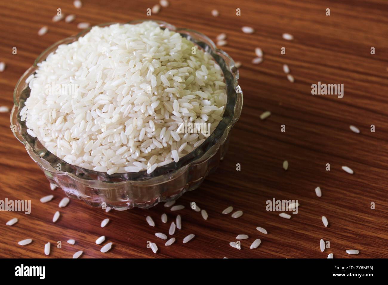 Ciotola di riso bianca isolata in legno, concetto di prodotti per il risparmio dell'acqua. Risparmio d'acqua. Orientamento orizzontale. Riso basmati crudo su legno Foto Stock