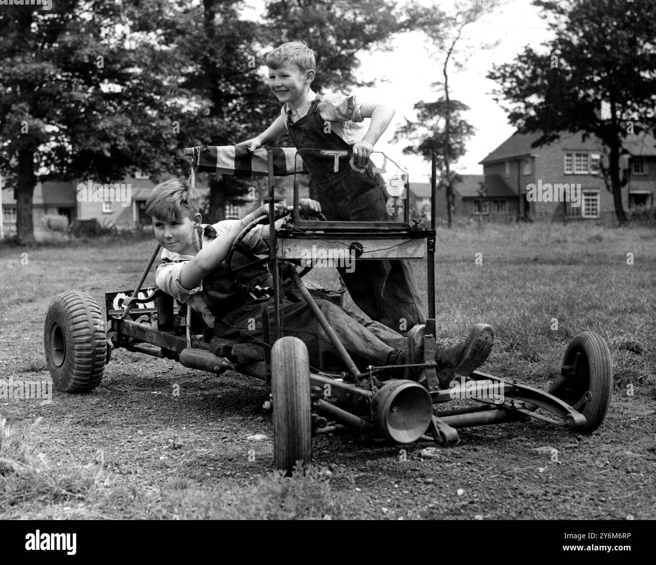 Lo studente speciale è stato costruito per niente. Prendendo una curva alla massima velocità, a circa 10 km/h nella loro auto "speciale" ci sono il dodicenne Richard Webb (alla guida e suo fratello di sei anni Edward, di Long Melford, Suffolk. I ragazzi lo costruirono da soli con un vecchio motore da 1/2 hp che il padre aveva ottenuto da una discarica del Ministero degli approvvigionamenti. 18 agosto 1954 Foto Stock