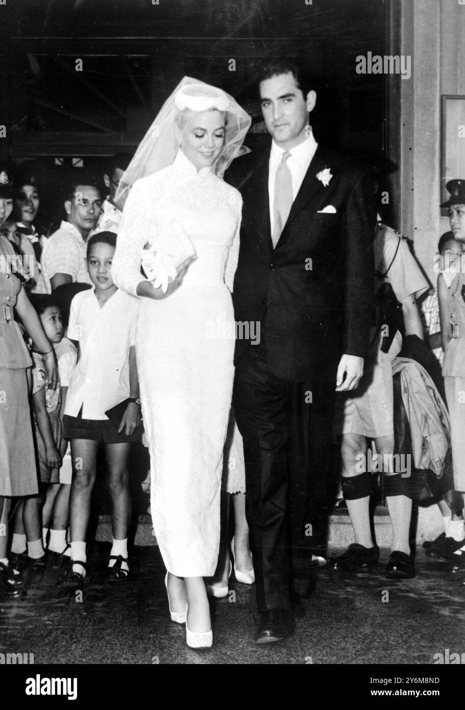 Hong Kong: Jacques Bergerac, ex marito di Ginger Rogers, ha un bacio per la sua nuova sposa il film americano attrice Dorothy Malone dopo il loro matrimonio a Hong Kong interpretato da padre Camelo Orlando alla chiesa cattolica romana di Santa Teresa. Bergerac ha cercato una dispensa speciale dal governatore per il normale periodo di attesa di quindici giorni, che avrebbe permesso loro di sposare immediatamente Bergerac, Miss Malone e la madre di Miss Malone sono arrivati a Hong Kong Tokyo di recente, dove Miss Malone ha girato un film il 28 giugno 1959 Foto Stock