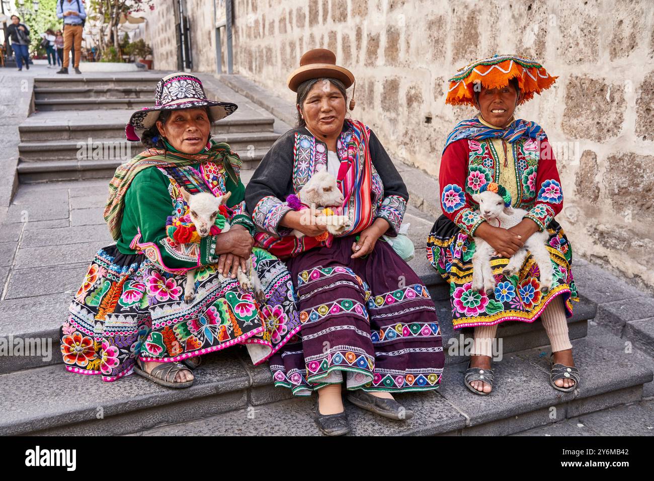 Donne peruviane in abiti tradizionali con agnelli sulla scalinata delle strade di Arequipa Foto Stock