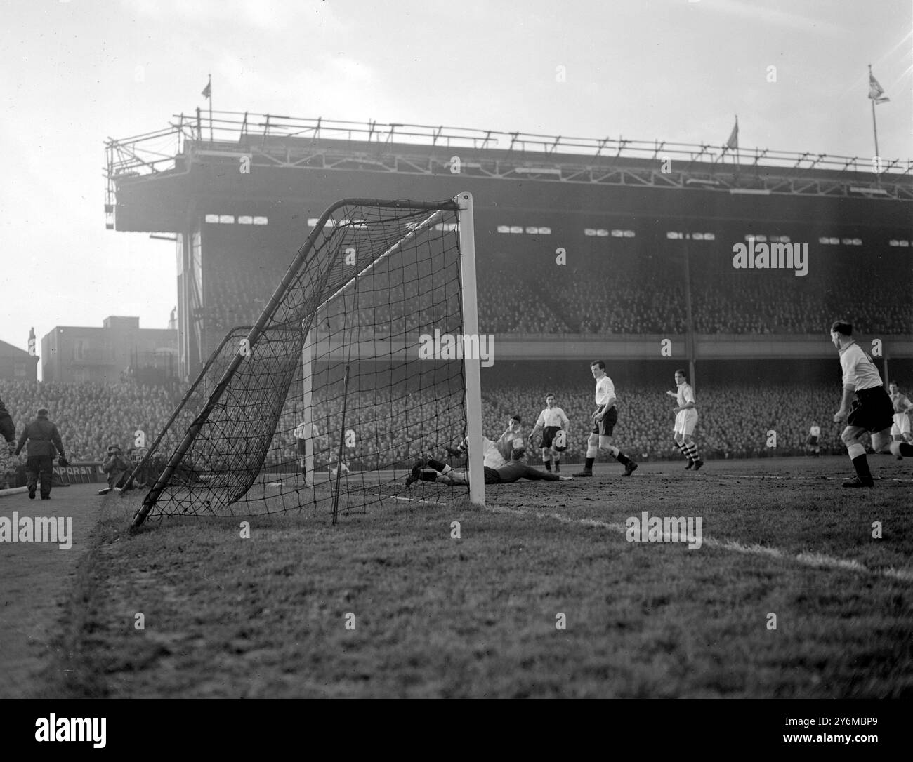 Il portiere del Blackpool Wiley si è allungato per tutta la lunghezza durante un attacco dell'Arsenal nella partita di calcio di First Division giocata oggi (lunedì) all'Arsenal Stadium di Highbury, Londra. Dietro Wiley c'è l'attaccante centrale degli Arsenals Holton (che cade) gli altri giocatori sono lasciati a destra Kelly, Blackpool metà sinistra; Crosland Blackpool metà centro; e Lishman Arsenal dentro sinistra. 28 dicembre 1953 Foto Stock