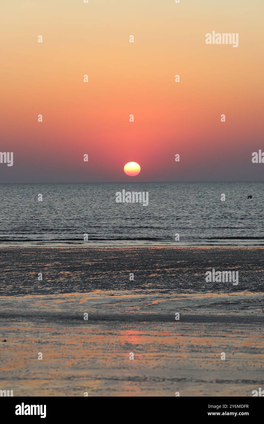 Splendido tramonto sul mare con colori iridescenti sulla superficie dell'acqua Foto Stock