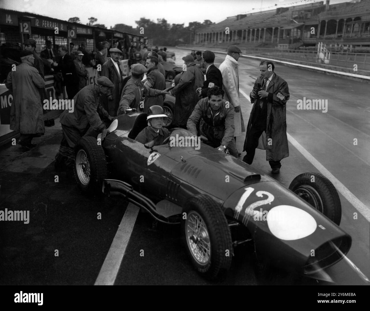 Mike Hawthorn è visto nella sua Ferrari italiana essere spinto fuori per un giro di prova sul campo Aintree. 19 luglio 1957 Foto Stock