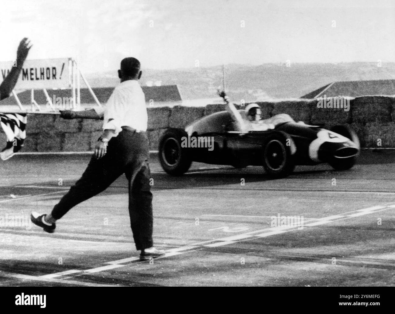 Il giudice si aggiudica il vincitore del Grand Prix Monsanto 1959 a Lisbona, Stirling Moss in una Cooper Climax (n 4) segnando la prima vittoria in campionato dell'attuale stagione per Moss. Moss sta alzando la mano per riconoscere gli applausi della folla. 25 agosto 1959 Foto Stock