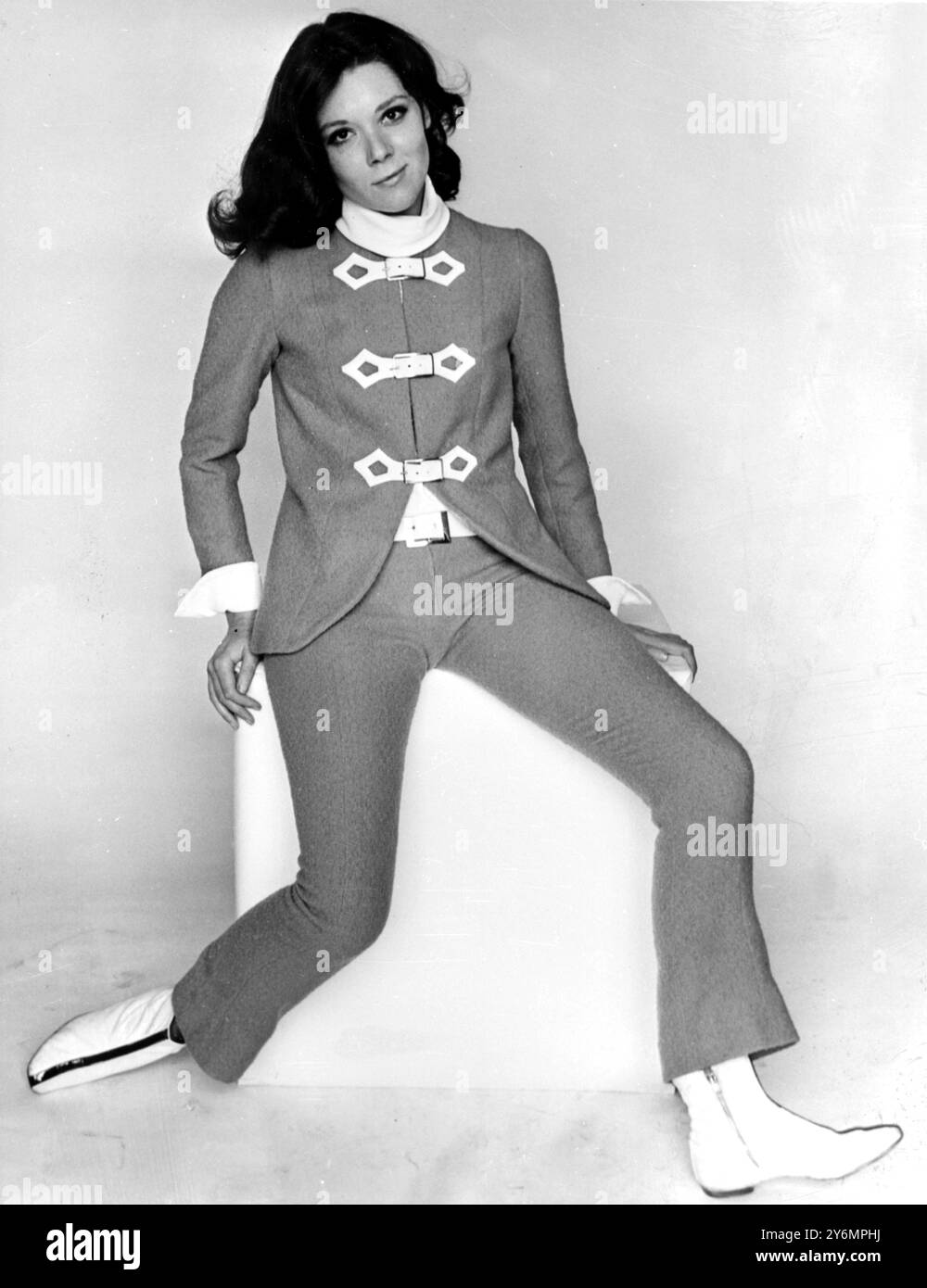 Londra: Diana Rigg indossa "V.I.P.", "il pantalone in lana di senape di Jean Varon disegnato da John Bates per il suo guardaroba "Emma Peel" in A.B.C. Television's Tongue in Cheek thriller, "The Avengers". Anche il quarto e ultimo episodio del 26 del thriller torna al P.V.C. fa la cintura. C'è una camicetta bianca in crepe e l'intero sit è venduto da Reginald Bernstein per 30!/' ghinee. Questa tuta non sarà vista in "The Avengers" fino al nuovo anno. 27 settembre 1965 Foto Stock