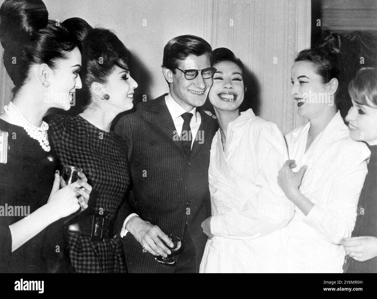 Parigi: Dopo la presentazione di oggi della "silhouette to Tomorrow", successore di Dior, il designer Yves St Laurent si congratula con i suoi nuovi manichini per il successo dello show: L/R Gilles, di Francia: E Rita di Germania, il 23enne St Laurent, ha reso i suoi precedenti stili di ambientazione abbastanza piatti sopra la vita con una linea generalmente sciolta. 27 gennaio 1960 Foto Stock