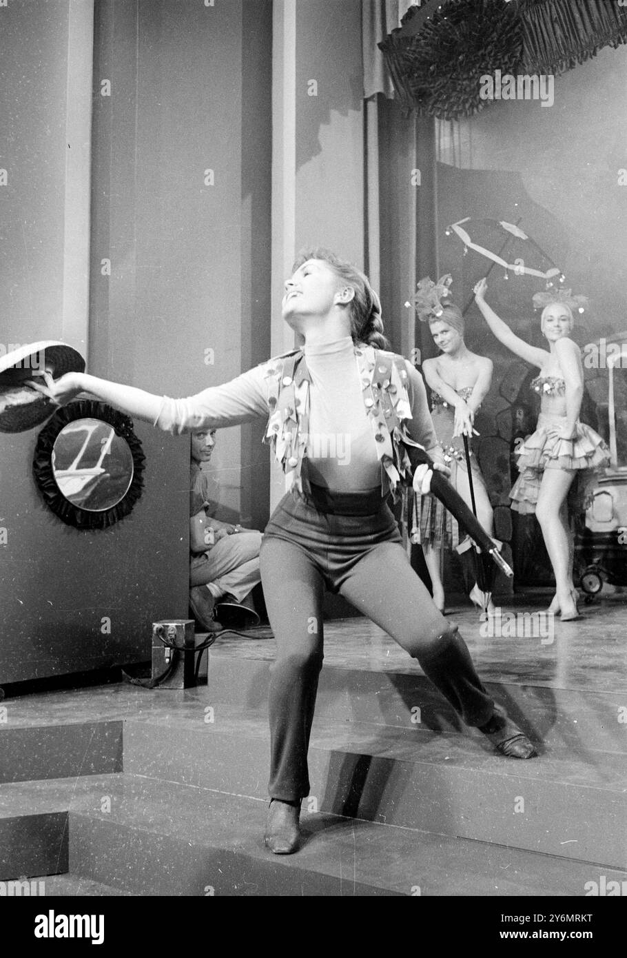 Hollywood, l'attrice statunitense Debbie Reynolds torna a girare dopo una recente serie di riprese con un'eccitante e torrida routine di tendenza che ha gli extra che riscuotono sul set. Debbie di recente e' dovuta andare in ospedale per un coagulo di sangue sul ginocchio. 14 febbraio 1959 Foto Stock