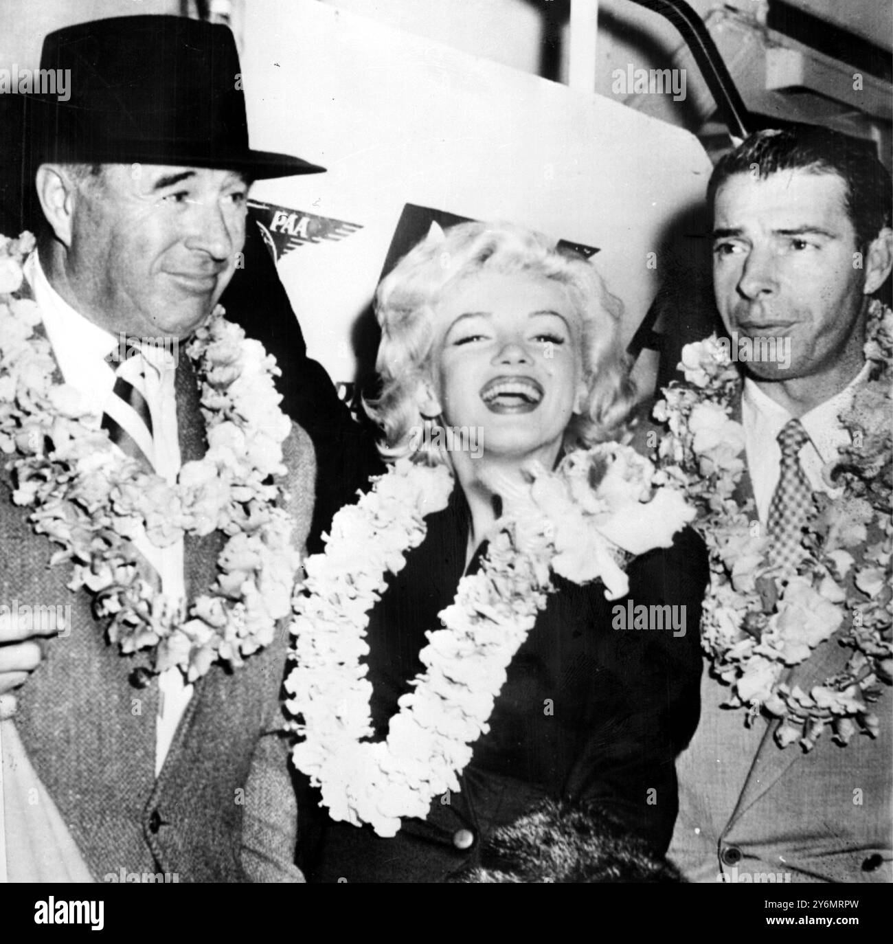 Honolulu: Regalarsi con un grande sorriso mentre si esibisce con la tradizionale leis floer, l'attrice pin-up di os Marilyn Monroe, che è arrivata qui con suo marito, Joe di maggio. La coppia in luna di miele è in viaggio per Tokyo per aprire la stagione di baseball giapponese del 1954. Febbraio 1954 Foto Stock