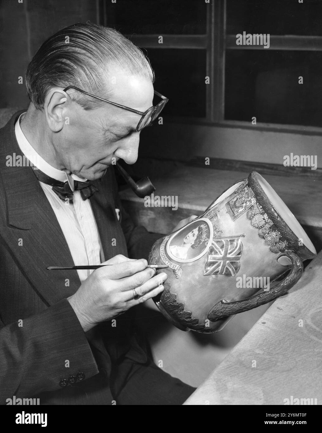 Souvenir dell'incoronazione lavorando sulla delicata decorazione dipinta a mano di una Coronation Loving Cup solo un migliaio di loro realizzati è il signor W e Grace un artista di spicco presso il Royal Doulton Potteries Staffordshire sul lato del ritratto a coppa della regina Elisabetta II con navi della marina elisabettiana sullo sfondo 1952 Foto Stock