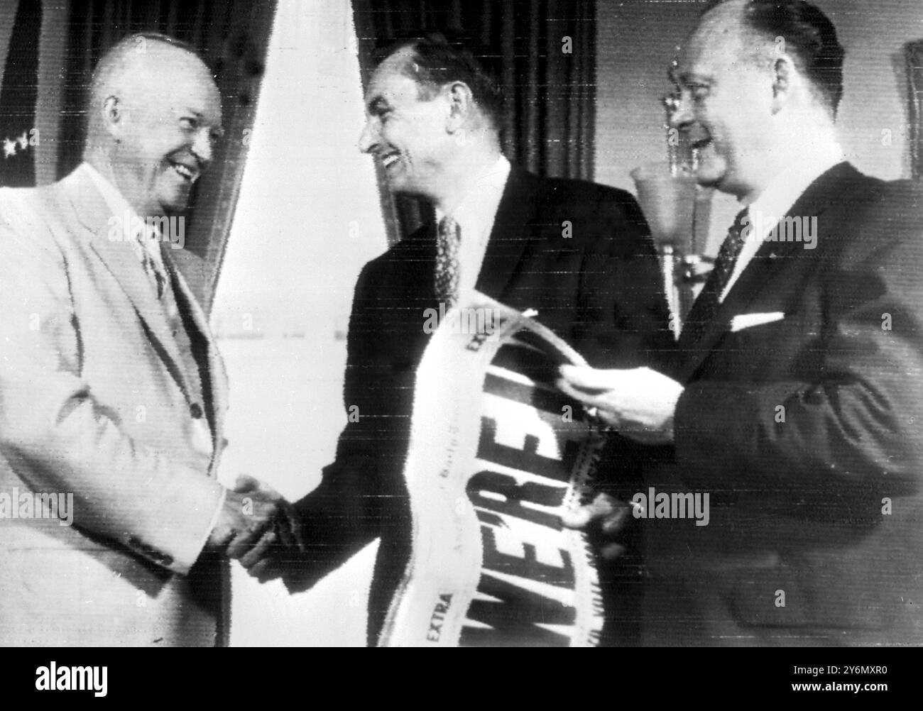 Washington, Stati Uniti: Il presidente Eisenhower stringe la mano al governatore dell'Alaska, Mike Stepovich, durante una visita alla Casa Bianca dopo che l'Alaska era stata votata 49° Stati. Il segretario degli interni seaton, detiene una copia dell'Anchorage Daily Times con i titoli audaci: "Siamo dentro". 2 luglio 1958 Foto Stock